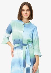 Rochie cu închidere tip buton, având un design gradient în nuanțe de albastru și verde, cu un curea legată și mâneci de lungime trei sferturi. Textură de țesătură netedă.