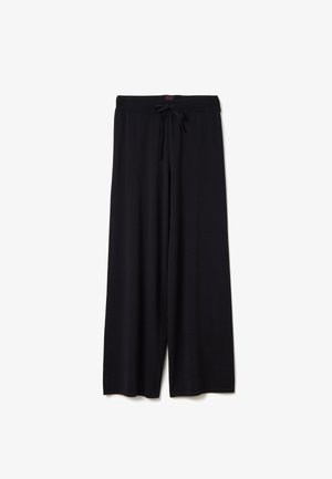 Zwarte wijde broek met een elastische tailleband en verstelbare trekkoordsluiting, weergegeven tegen een witte achtergrond.