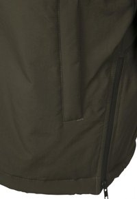 Tissu vert foncé avec coutures visibles, avec une fermeture éclair noire verticale sur le côté droit et un détail rectangulaire cousu à proximité.