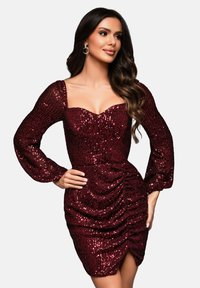 Robe en sequins bourgogne avec de longues manches bouffantes, décolleté en cœur, silhouette ajustée, et détails froncés à la taille et à la jupe.