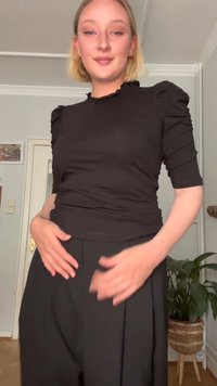 Juodas prigludęs marškinėlis su pūstomis rankovėmis ir raukinėtu iškirpimu, derinamas su laisvais juodais kelnais. Lycra audinys su subtiliomis tekstūros detalėmis.