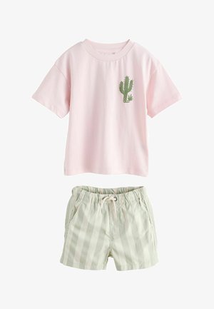 Pink kortærmet skjorte med grøn kaktusgrafik kombineret med lysebeige stribede shorts med snøre til afslappet brug.