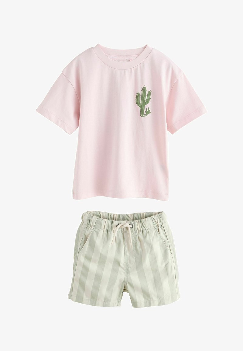 Chemise rose à manches courtes avec un motif de cactus vert, associée à un short beige clair à rayures avec cordon de serrage pour une tenue décontractée.