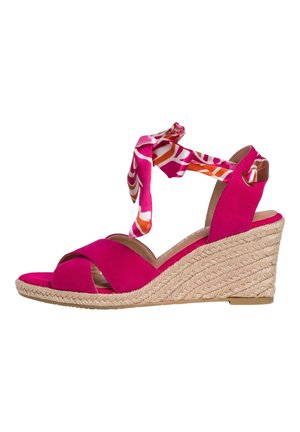 Pink wedge sandal with cross-over straps, fabric ankle tie, and woven jute sole. Smooth texture with a pop of color and vibrant design accents.