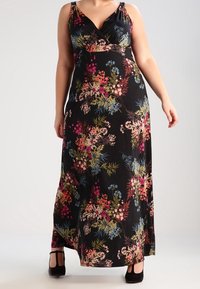 Blommig maxiklänning i svart med V-ringning, prydd med färgglada blommönster i rosa, blått och grönt. Slät tygkvalitet och flödande silhuett.