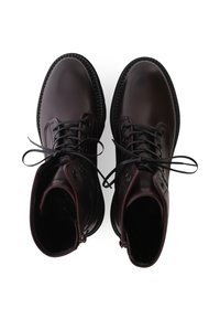 Bottines en cuir brun avec bout rond, semelle en caoutchouc noire et lacets noirs. Présente des œillets latéraux et un design supérieur sans couture.