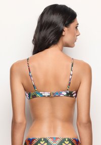 Top bikini colorato e a fantasia con spalline regolabili e chiusura con gancio dorato. Il materiale ha una texture liscia e presenta un motivo floreale multicolore.