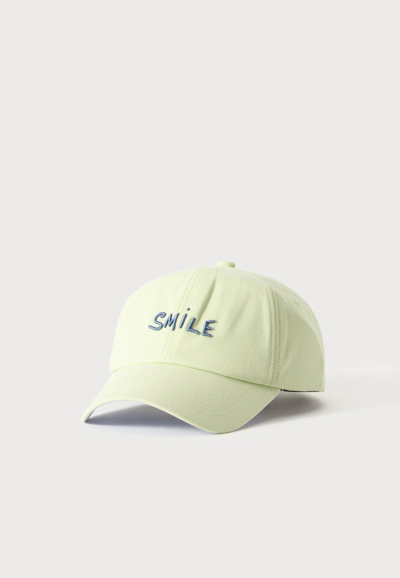Casquette de baseball jaune clair avec le mot brodé en bleu "SMILE" à l'avant, présentée sur fond blanc uni.