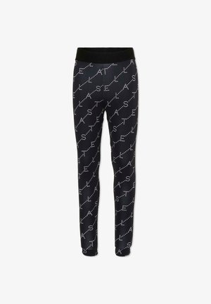 Pantalon noir ajusté avec des lettres blanches en points formant le mot "ASTEL" répété en diagonale sur le tissu.