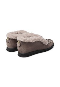 Pantofole grigie in suede con una morbida fodera leggera in pelliccia e suole in gomma nera. Presentano un motivo decorativo sulla punta e accessori in evidenza.