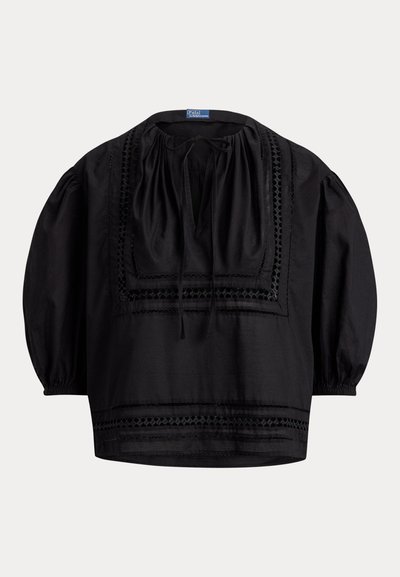 Μαύρο φαρδύ μπλουζάκι με φουσκωτά μανίκια, τετράγωνο ντεκολτέ, μπροστινό δέσιμο και κεντητό γεωμετρικό διακοσμητικό στο στήθος και το τελείωμα.