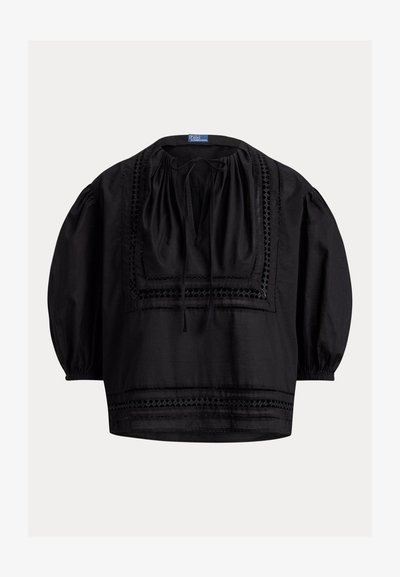 Μαύρο φαρδύ μπλουζάκι με φουσκωτά μανίκια, τετράγωνο ντεκολτέ, μπροστινό δέσιμο και κεντητό γεωμετρικό διακοσμητικό στο στήθος και το τελείωμα.