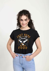 Sort bomulds t-shirt med et vaskebjørn grafik og teksten "BARE HER for MAD" i orange og hvid. Korte ærmer, afslappet pasform.