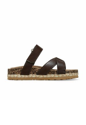 Sandal in pelle marrone con cinturini incrociati, soletta in sughero e suola avvolta in juta. Sottopiede in gomma piatta per aderenza e stabilità.