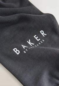 Dark gray fabric with a textured surface, featuring the bold, white text "BAKER" and "by TED BAKER" in a modern font.