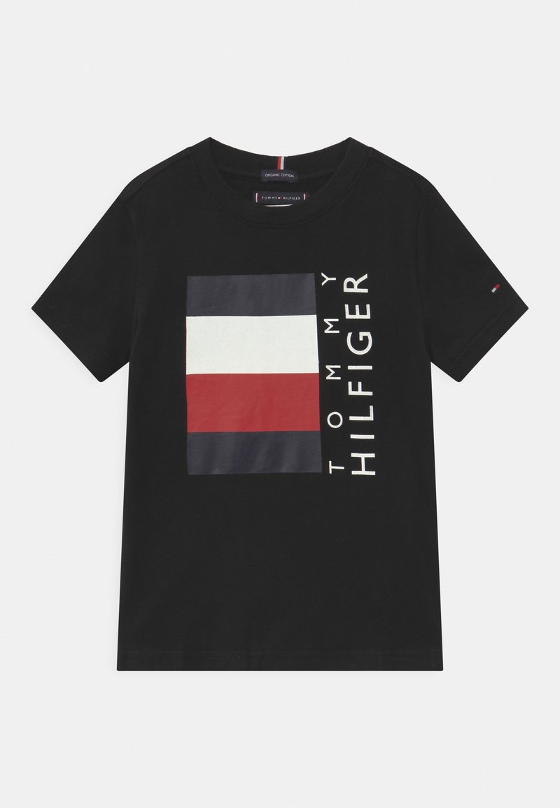 Camiseta negra de manga corta hecha de algodón orgánico, que presenta un gráfico llamativo con rayas rojas, blancas y azules marino, y el texto "TOMMY HILFIGER".
