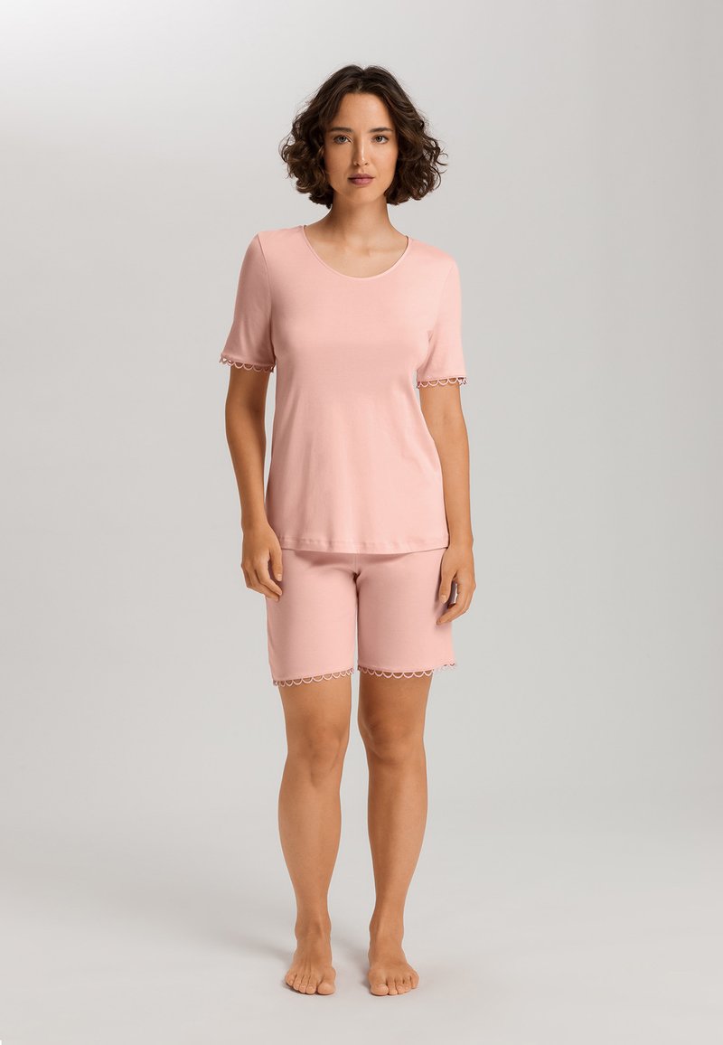 Rosa lounge-set med en kortärmad topp och knälånga shorts, båda med scallop-detaljer. Mjuk, slät tyg med avspänt passform.