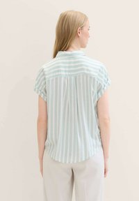 Light blue and white striped shirt with short rolled sleeves, collared neck, back pleat, and curved hem. Smooth fabric texture.