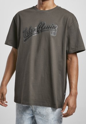 Szara bawełniana koszulka z okrągłym dekoltem, ozdobiona czarnym napisem "Urban Classics 05" na piersi. Luźny krój z krótkimi rękawami.