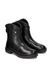Black leather ankle boots with a rounded toe, flat sole, and a strap featuring a gold button accent on the side. Smooth texture.