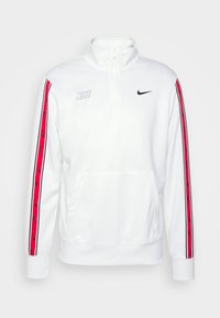 Vit Nike-hoodie med hög krage, halvdragkedja och röda sidostraper med svarta logotyper. Mjukt material med en framficka i kängurustil.