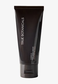 Schwarze Tube der True Botanicals Chebula Handcreme mit glatter Textur; mit weißem und metallicfarbenem Text. Schlankes, modernes Design.