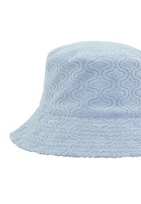 Ljusblå bucket-hatt gjord av mjuk frotté med ett strukturerat vågmönster och en bred, flexibel brätte. Passar för avslappnad användning.