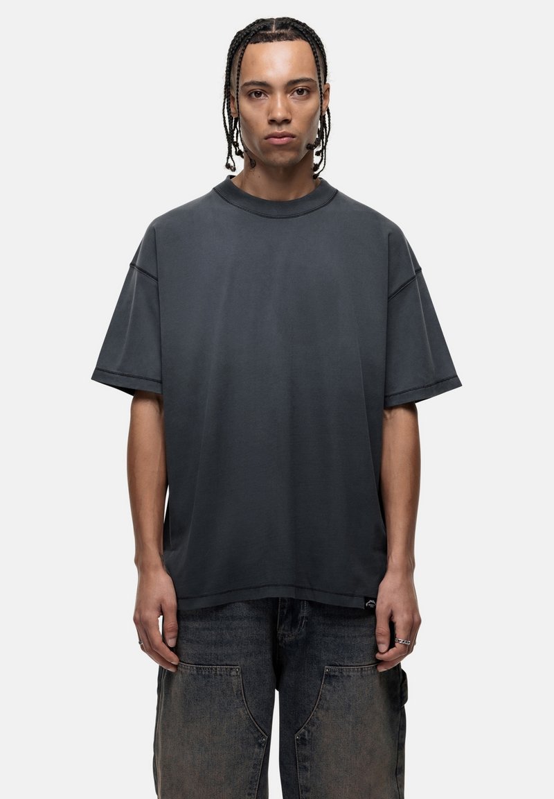 Przyduży, ciemnoszary T-shirt, krótki rękaw, okrągły dekolt, uszyty z miękkiego materiału, z prostym wykończeniem i minimalnymi detalami szwów.