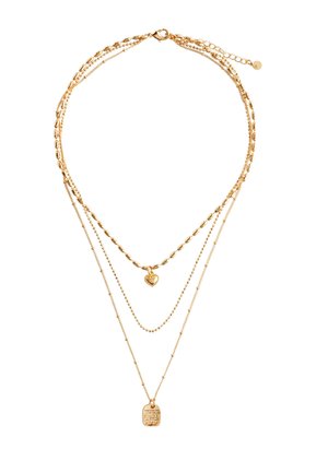 Guld lagdelt halskæde med forskellige kædedesigns, herunder ovale led, små perler og en central hjertevedhæng med en inskription på et mærke.