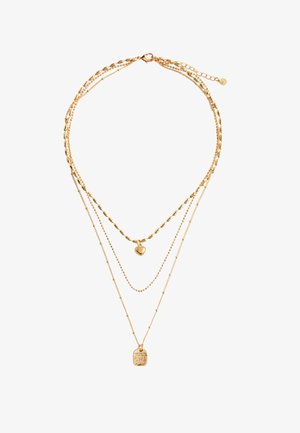 Guld lagdelt halskæde med forskellige kædedesigns, herunder ovale led, små perler og en central hjertevedhæng med en inskription på et mærke.