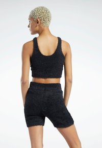 Svart, fuzzy cropped tank topp og matchende shorts, med teksturert stoff, elastisk midje og brede armhull for komfort.