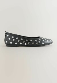 Black leather flats with a rounded toe, featuring silver circular studs evenly spaced across the upper surface and a low heel.