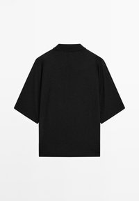 Sort kortærmet polo med flad krave, lavet af et glat, let materiale, der har en afslappet pasform og rene linjer.