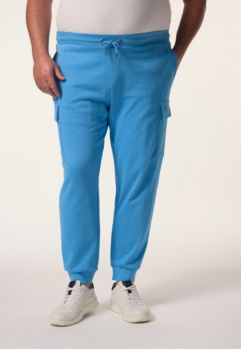 Hellblaue Sweatpants mit elastischem Bund und Zugband, mit seitlichen Taschen und umgeschlagenen Knöcheln. Hergestellt aus weichem Stoff.