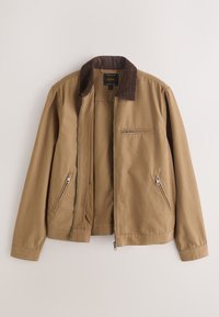 Veste marron clair avec un col en velours marron foncé, trois poches zippées et une fermeture éclair à l'avant sur un fond uni.