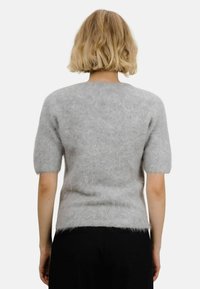 Grå kortermet, fluffy genser laget av mykt, teksturert materiale, med rund hals og en tettsittende silhuett.