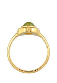 Bague en or avec une pierre précieuse verte arrondie en haut, un anneau lisse et une finition polie avec un éclat constant.