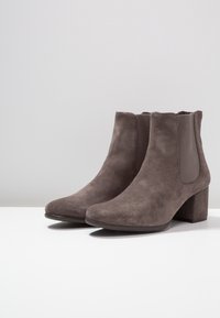 Bottines en daim grises avec une texture lisse, bout rond et talon bloc moyen ; panneaux élastiques latéraux pour un enfilage facile.