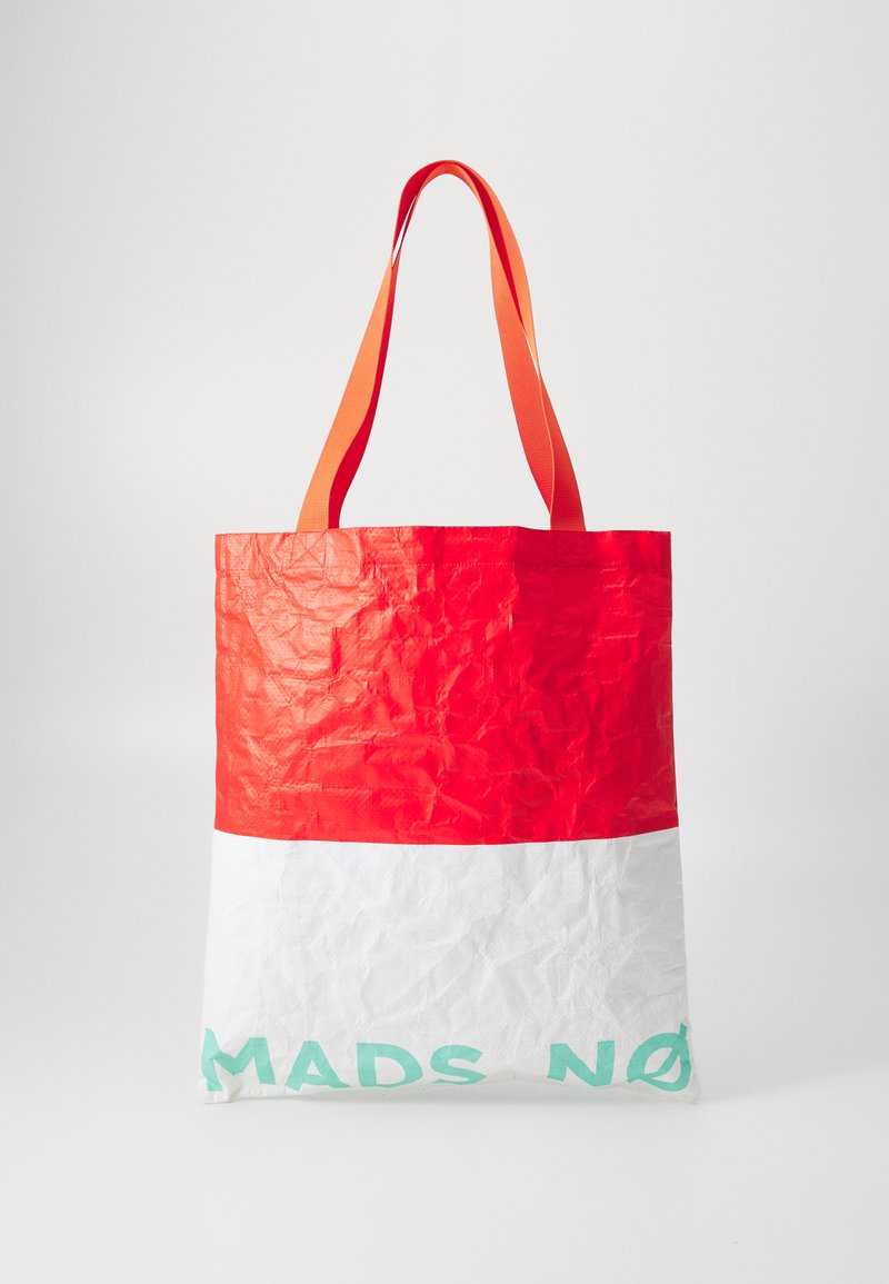 Sac fourre-tout rouge et blanc en matériau froissé, avec des anses orange et le texte "MADS NØ" en vert menthe en bas.