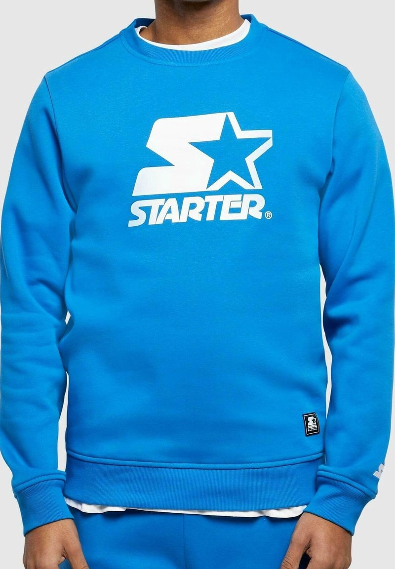 Felpa blu in misto cotone, con logo bianco "STARTER" e design a stella sul davanti. Polsini e orlo a costine con etichetta del logo sul fondo.
