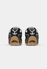 Adidași negri și maro văzuți din spate, având logo-ul alb Adidas trefoil și tălpi din cauciuc texturate.