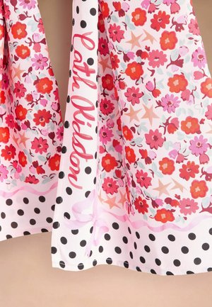 Różowy i czerwony kwiatowy dół sukienki z czarną kropkowaną lamówką i napisem "Patta Oldsp" na białym materiale.