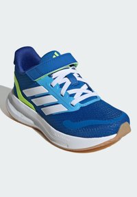 Blaue Sportschuhe mit einem Obermaterial aus Mesh und weißen Streifen. Verfügt über einen Klettverschluss, eine Gummisohle und ein strukturiertes Design. Akzente in Grün und Blau.