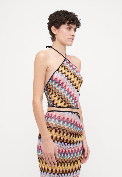 Flerfärgad halterneck-top med zigzag-mönster i rosa, blått, gult och brunt. Svart kant längs halsringning och nederkant. Sittande design.