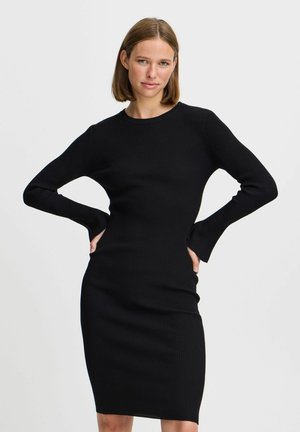 Schwarzes geripptes Strickkleid mit langen Ärmeln, Rundhalsausschnitt und figurbetontem Schnitt. Mit einem knielangen Saum und subtiler Textur.