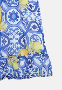 Μπλε φόρεμα με σχέδια που περιλαμβάνει ανθικά στοιχεία, γραφικά με λεμόνια και βολάν στο τελείωμα. Κατασκευασμένο από ελαφρύ ύφασμα με περίπλοκα σχεδιαστικά στοιχεία.