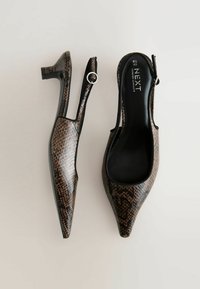 Talons hauts à bride arrière en cuir façon peau de serpent brun et noir avec un petit talon carré et des accents argentés ronds sur les brides. Finition intérieure lisse.