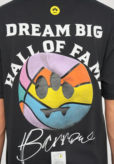 Maglietta nera con una grafica colorata di un pallone da basket con trame, testo bianco in grassetto che recita "DREAM BIG HALL OF FAME" e un piccolo dettaglio del logo.