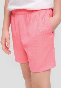 Rosa strukturierte Shorts mit einem elastischen Bund, seitlichen Taschen und einer lässigen Passform, die für Komfort und Bewegungsfreiheit entwickelt wurden.