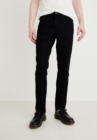 Jeans negri din denim cu o croială slim, având cinci buzunare, o textură netedă și închidere cu un nasture metalic. Asortați cu pantofi negri cu șiret.